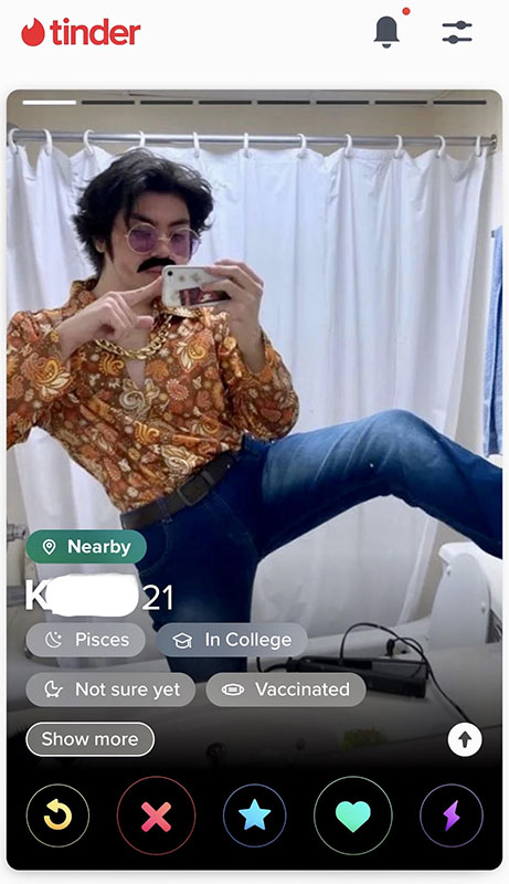 A screenshot of a Tinder profile of someone named K. K is dressed for a disco.